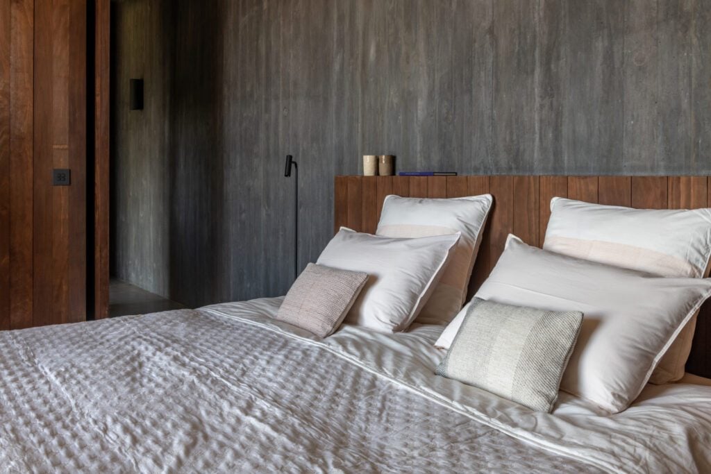 La suite principale : lit king size, coussins de lin, béton ciré